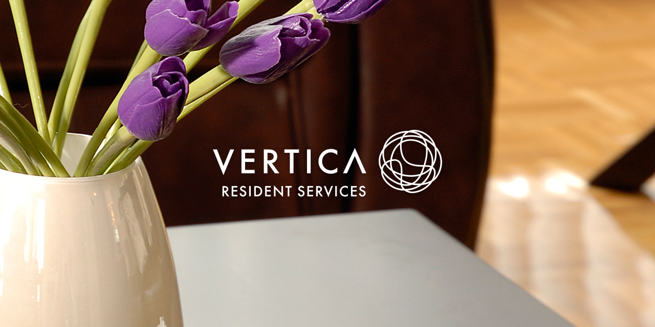 Table and purple tulips in a living space with the Vertica Resident Services Logo overlayed on top of it